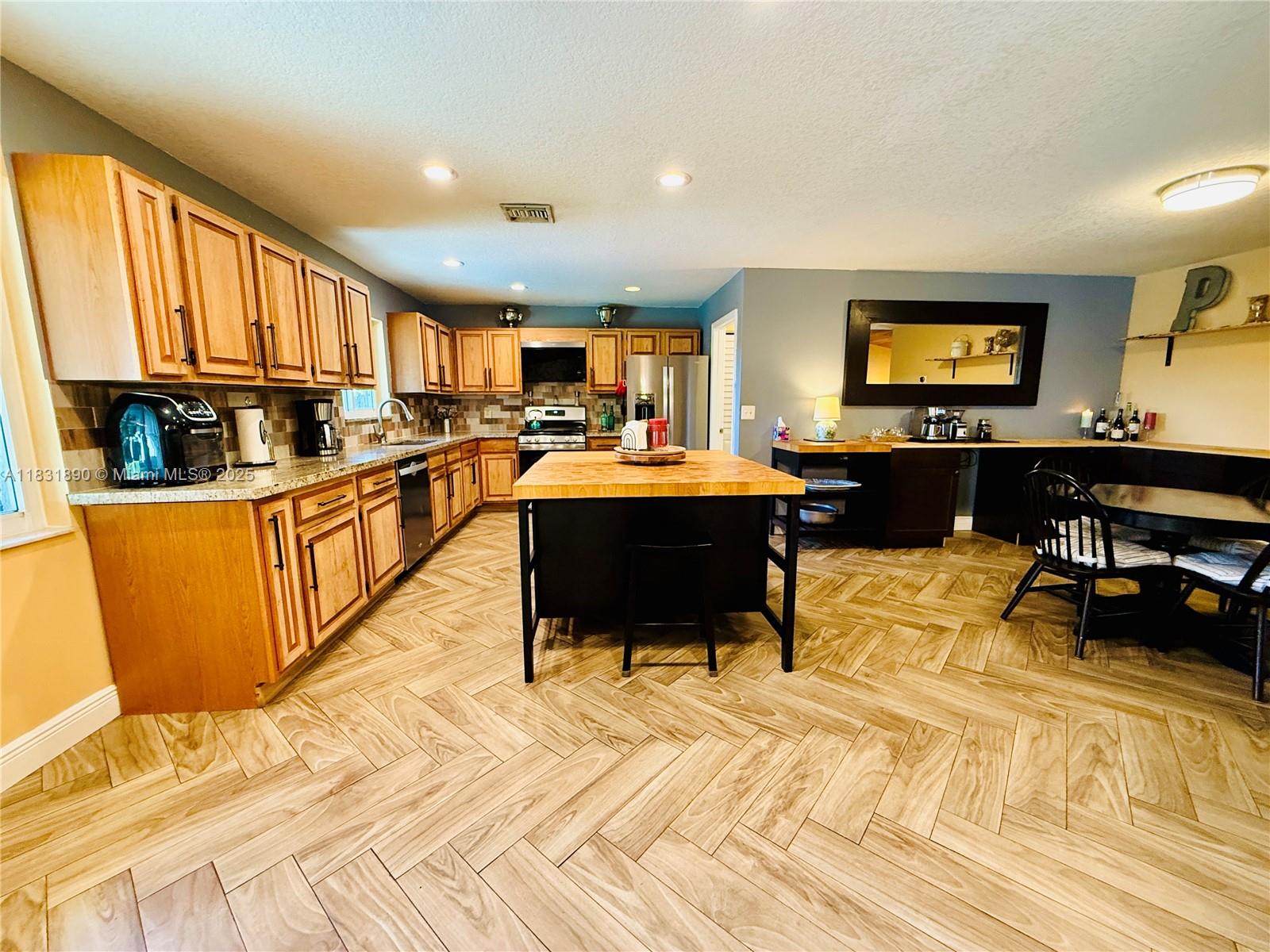 2980 Southwest 82nd Way Davie, FL 33328 - Photo 8 of 39 a view of a kitchen with kitchen island granite countertop wooden floors and a sink