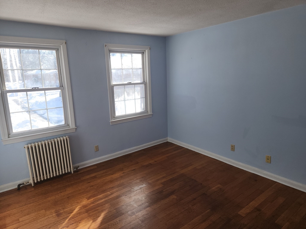 456 Cold Spring Avenue, Unit 2A West Springfield, MA 01089 - Photo 2 of 13 an empty room with wooden floor and windows