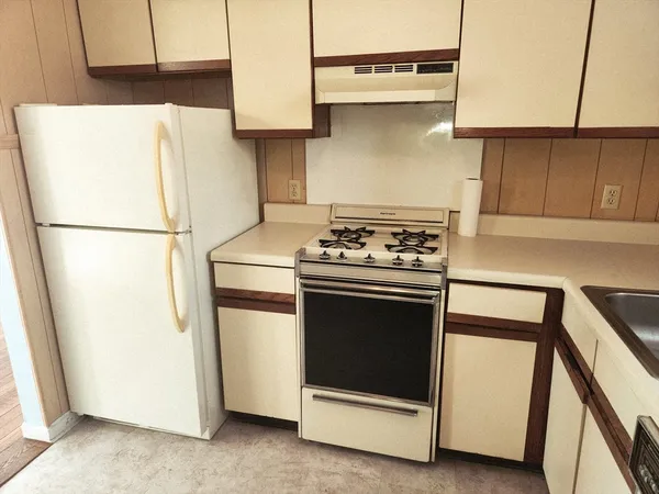 a white refrigerator freezer and a stove sitting inside of a kitchen