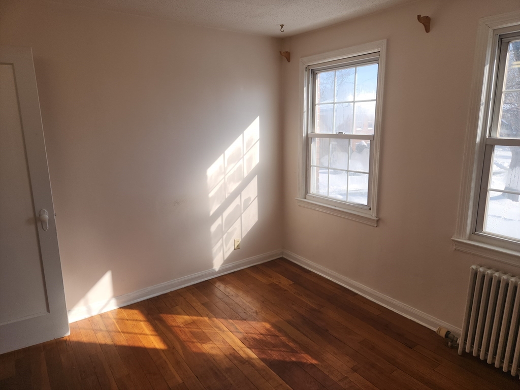 456 Cold Spring Avenue, Unit 2A West Springfield, MA 01089 - Photo 7 of 13 an empty room with wooden floor and windows