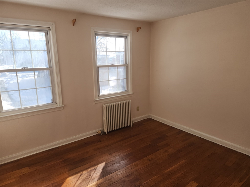 456 Cold Spring Avenue, Unit 2A West Springfield, MA 01089 - Photo 8 of 13 an empty room with wooden floor and windows