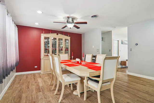 a dining room with furniture a chandelier and wooden floor