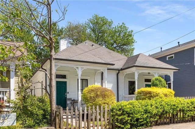a view of a white house with large windows and plants