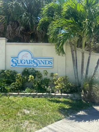 a view of sign board with tall trees