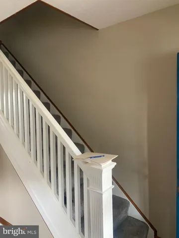 a view of staircase with railing and white walls