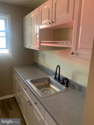 a kitchen with a sink cabinets and a window