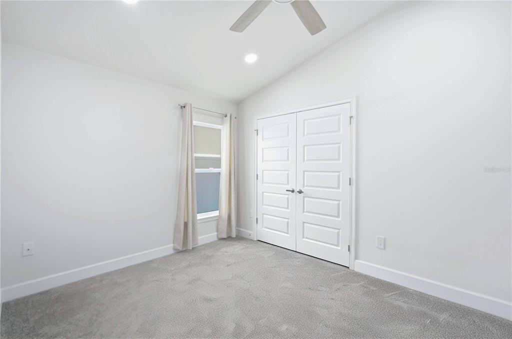 12945 Ogden Glade Road Dade City, FL 33525 - Photo 14 of 26 an empty room with closet and a ceiling fan