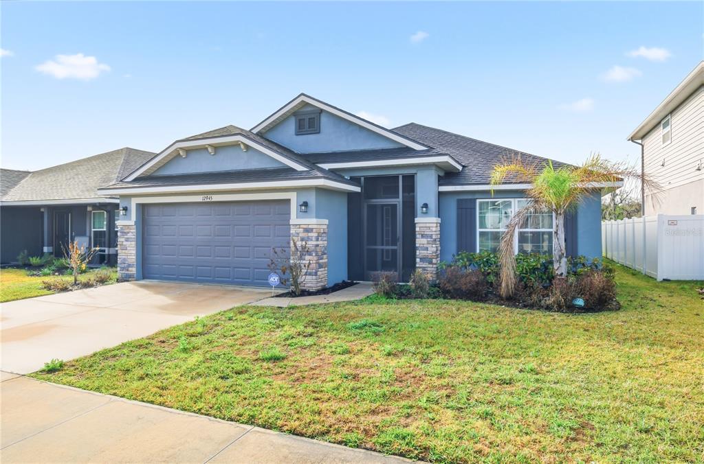 12945 Ogden Glade Road Dade City, FL 33525 - Photo 3 of 26 a front view of a house with a yard and garage