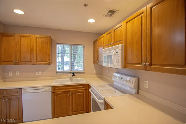 a kitchen with stainless steel appliances granite countertop a sink a stove and a microwave