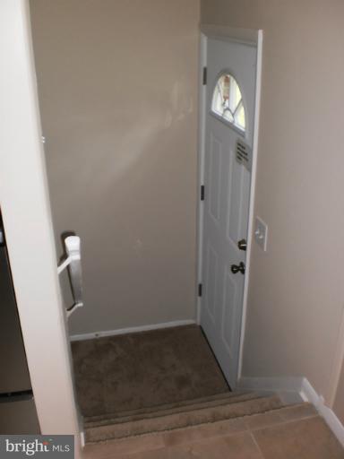 9027 Samoset Road Randallstown, MD 21133 - Photo 20 of 23 an empty room with wooden floor mirror and door