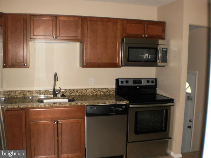 9027 Samoset Road Randallstown, MD 21133 - Photo 7 of 23 a kitchen with stainless steel appliances granite countertop a stove microwave and sink