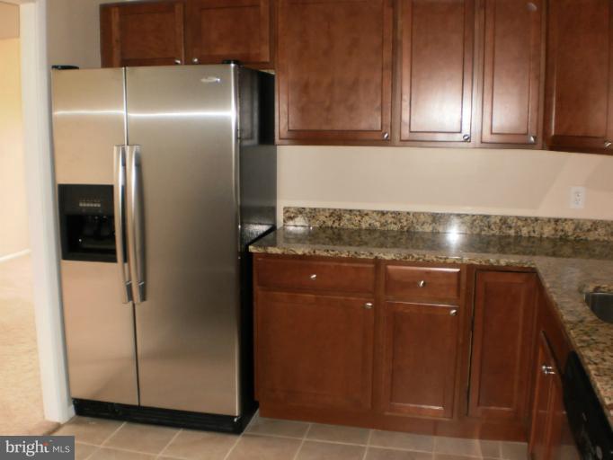 9027 Samoset Road Randallstown, MD 21133 - Photo 8 of 23 a kitchen with granite countertop stainless steel appliances a refrigerator and cabinets