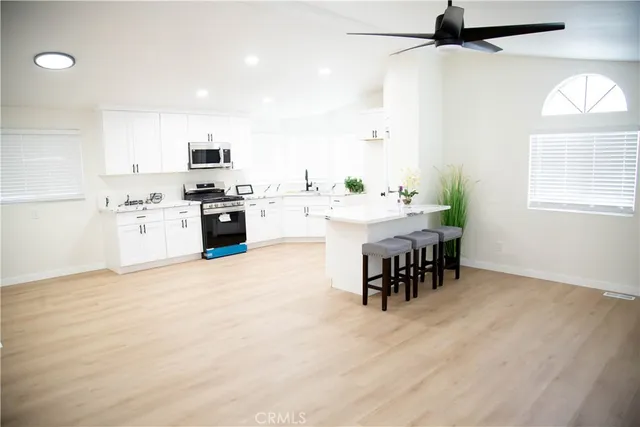 a kitchen with kitchen island a stove a table and chairs in it