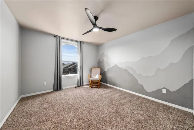 a view of a room with a ceiling fan and window
