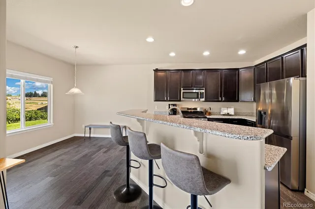 a kitchen with kitchen island appliances cabinets and wooden floor