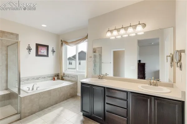 a bathroom with a tub double sink and mirror