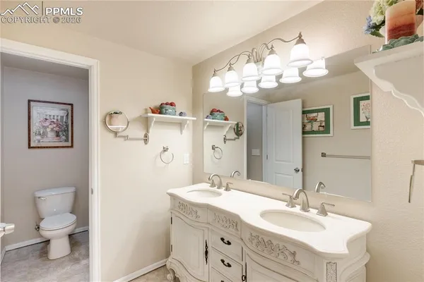 a bathroom with a double vanity sink mirror and toilet