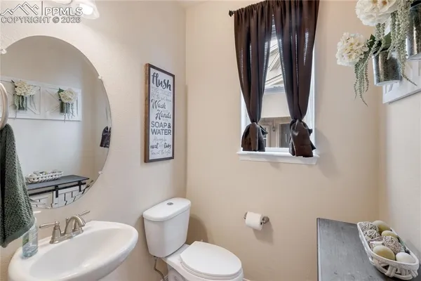 a bathroom with a toilet a sink and mirror