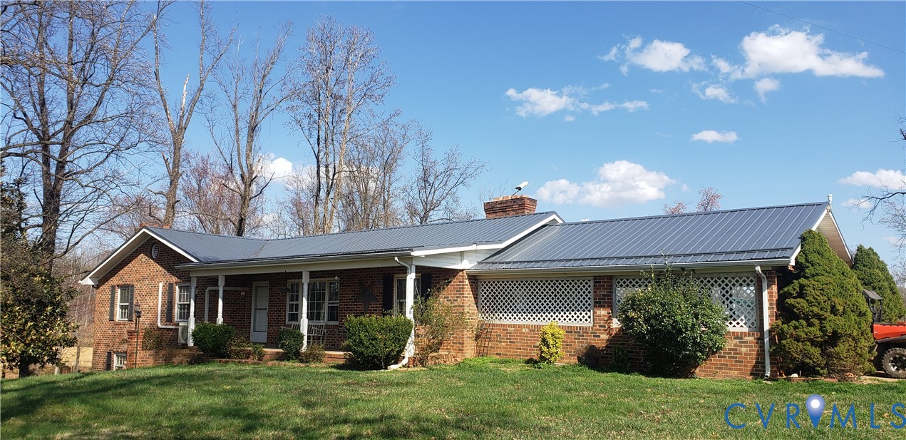 23381 Genito Road Jetersville, VA 23083 - Photo 2 of 29 a view of a house with brick walls and a yard with plants