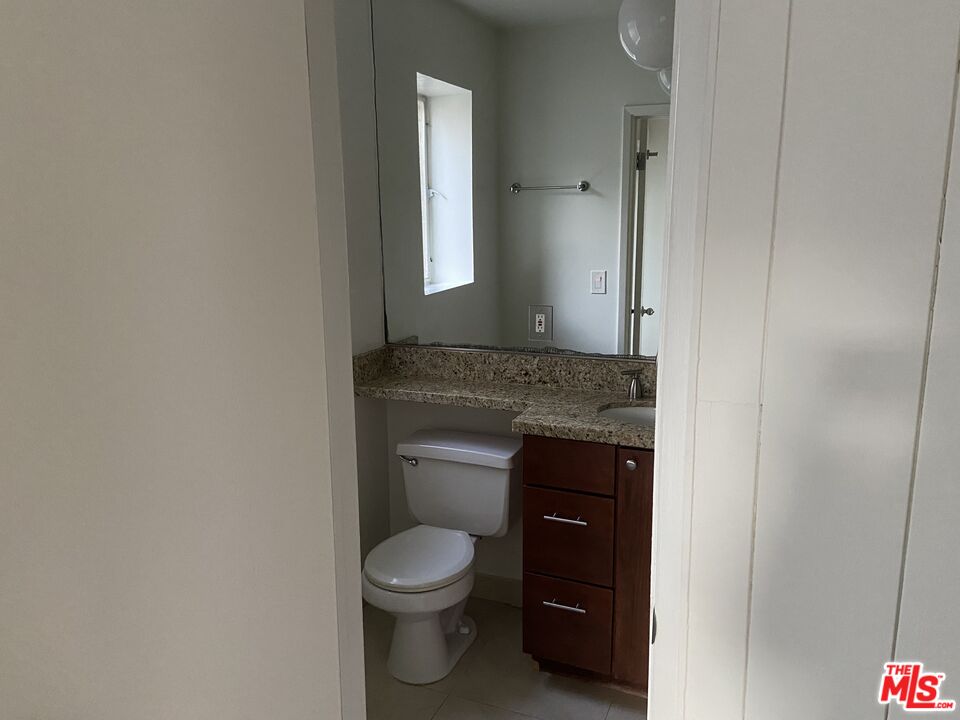 10655 Wilshire Boulevard, Unit 303 Los Angeles, CA 90024 - Photo 11 of 27 a bathroom with a granite countertop toilet and a sink
