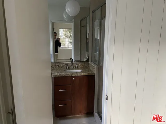 a bathroom with a granite countertop sink and a mirror