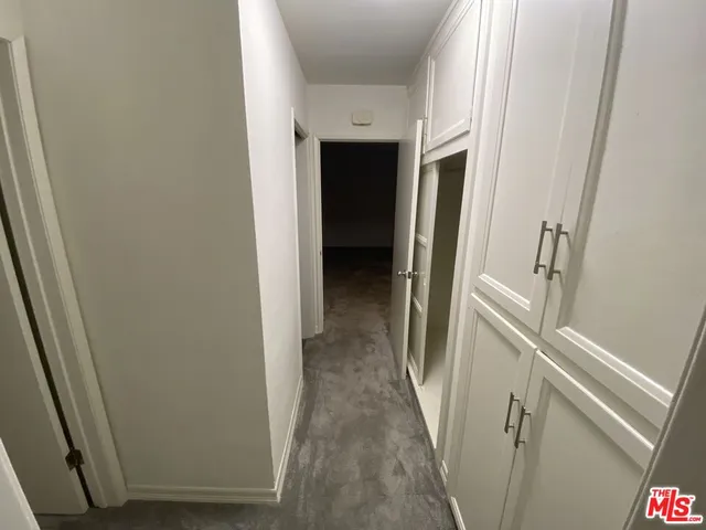 a kitchen with stainless steel appliances a refrigerator a sink a stove and white cabinets