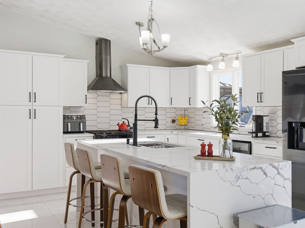 39 Swan Avenue Methuen, MA 01844 - Photo 4 of 42 a kitchen with stainless steel appliances a sink a stove a table and chairs