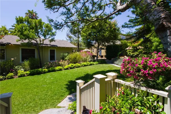 a view of a backyard with plants and a fountain