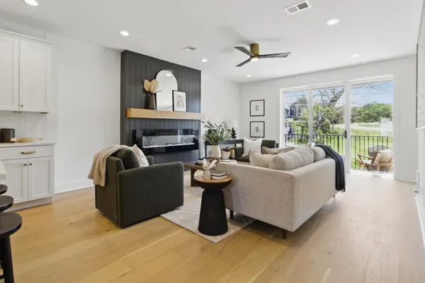 a living room with furniture a fireplace and a floor to ceiling window