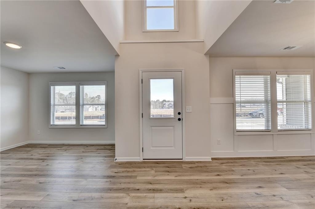 646 Rodeo Drive Auburn, GA 30011 - Photo 2 of 26 an empty room with wooden floor and windows