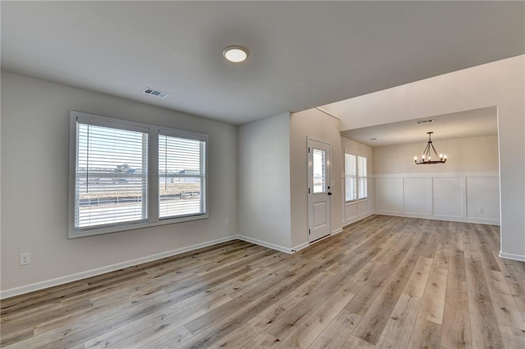 646 Rodeo Drive Auburn, GA 30011 - Photo 5 of 26 a view of an empty room with wooden floor and a window