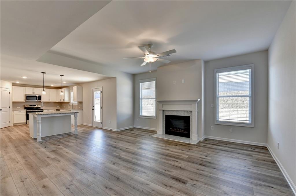 646 Rodeo Drive Auburn, GA 30011 - Photo 10 of 26 a living room with stainless steel appliances kitchen island a fireplace and wooden floor
