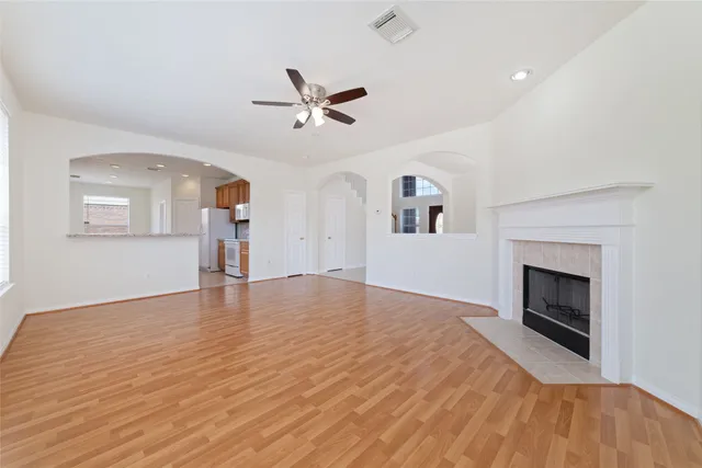 a view of empty room with wooden floor and fireplace