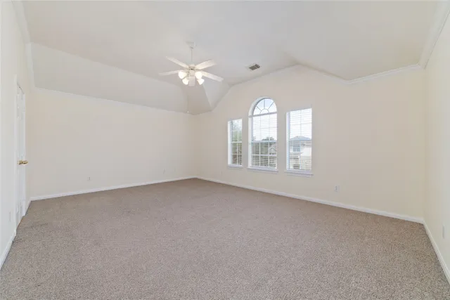 an empty room with a window and ceiling fan
