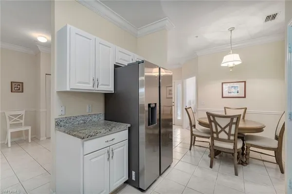 a kitchen with a table chairs and refrigerator