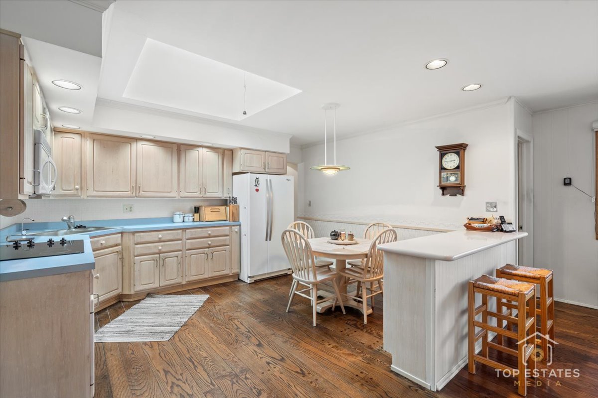 1802 Aspen Drive Mount Prospect, IL 60056 - Photo 13 of 30 a kitchen with a dining table chairs refrigerator and cabinets