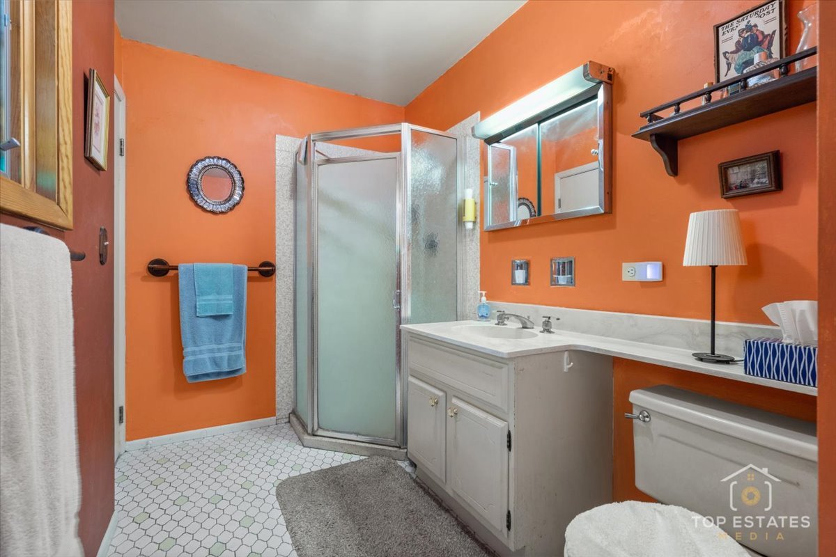 1802 Aspen Drive Mount Prospect, IL 60056 - Photo 19 of 30 a bathroom with a sink a mirror a lamp and front door