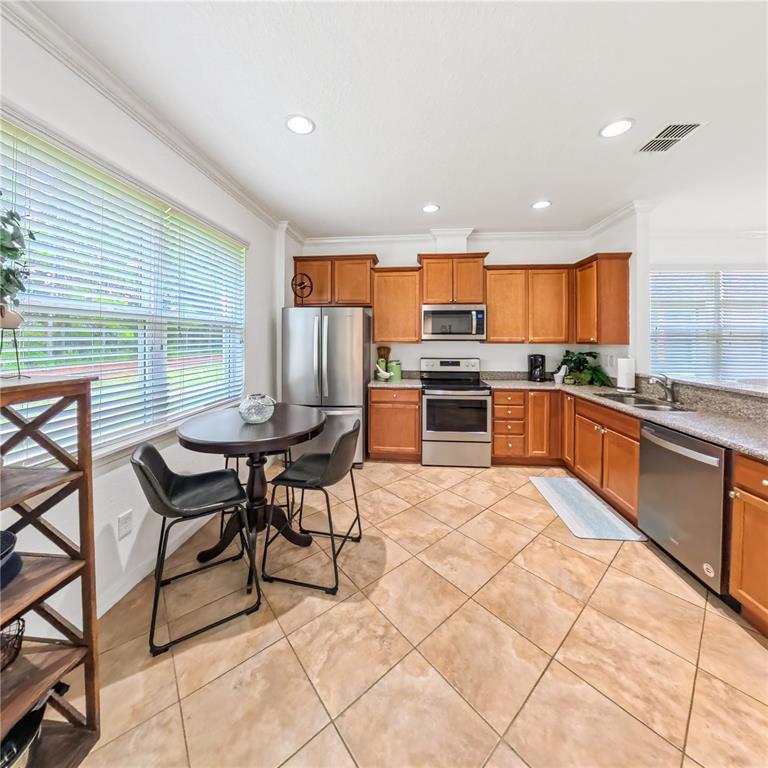9117 Southwest 70th Loop Ocala, FL 34481 - Photo 11 of 24 a kitchen with stainless steel appliances kitchen island granite countertop a sink and cabinets