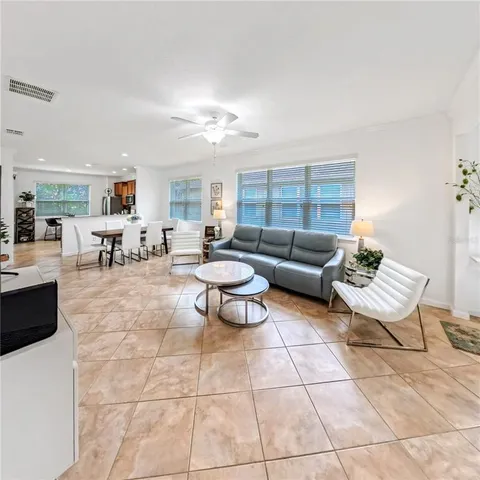 a living room with furniture and a dining table with kitchen view
