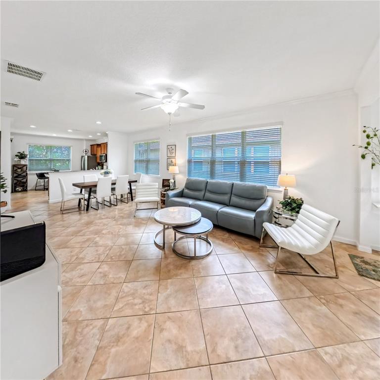 9117 Southwest 70th Loop Ocala, FL 34481 - Photo 8 of 24 a living room with furniture and a dining table with kitchen view