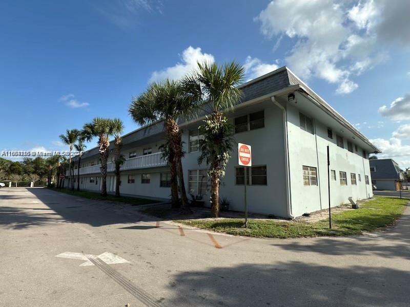 4271 Northwest 5th Street, Unit 108 Plantation, FL 33317 - Photo 3 of 6 a front view of a house with a yard and garage