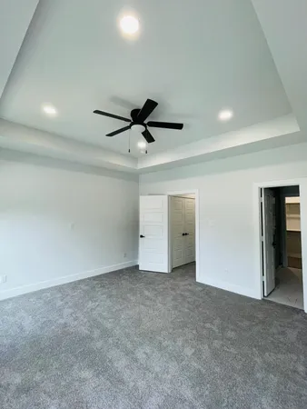 an empty room with fan and windows