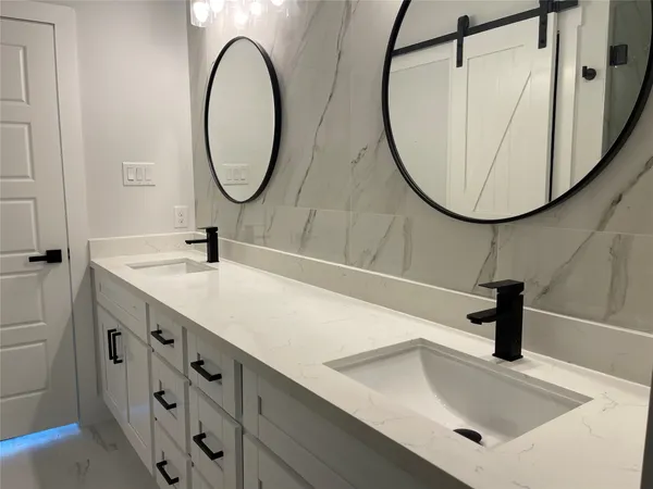 a bathroom with double vanity sink and a mirror