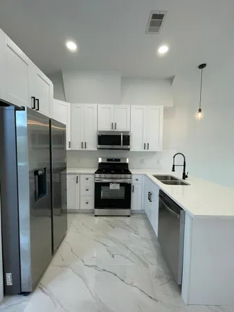 a view of kitchen with stainless steel appliances a refrigerator and a stove top oven