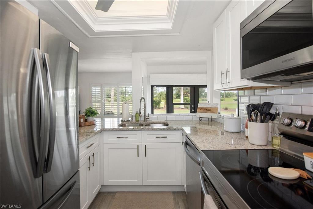 5665 Trailwinds Drive, Unit 616 Fort Myers, FL 33907 - Photo 11 of 29 a kitchen with stainless steel appliances granite countertop a sink stove and refrigerator