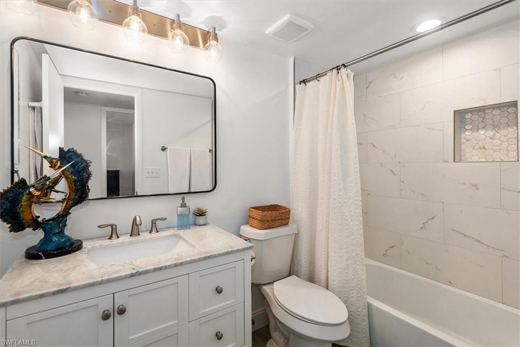 5665 Trailwinds Drive, Unit 616 Fort Myers, FL 33907 - Photo 16 of 29 a bathroom with a granite countertop sink toilet mirror and shower