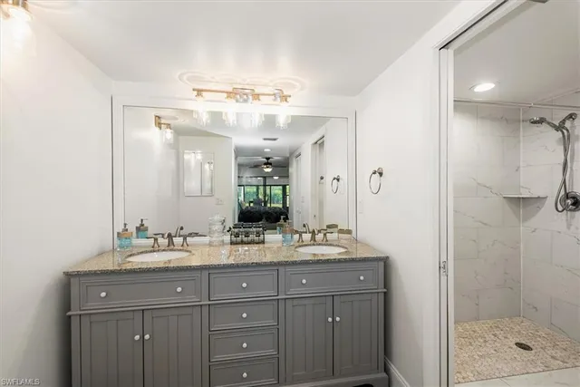 a spacious bedroom with a bed and a lamp on the dresser