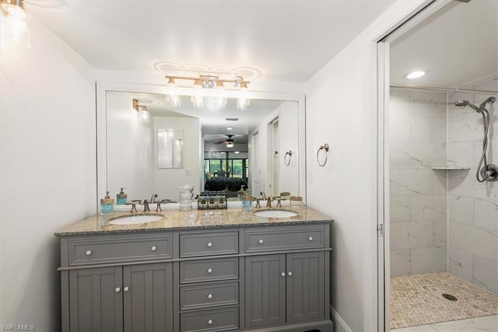 5665 Trailwinds Drive, Unit 616 Fort Myers, FL 33907 - Photo 19 of 29 a bathroom with a sink shower and a mirror