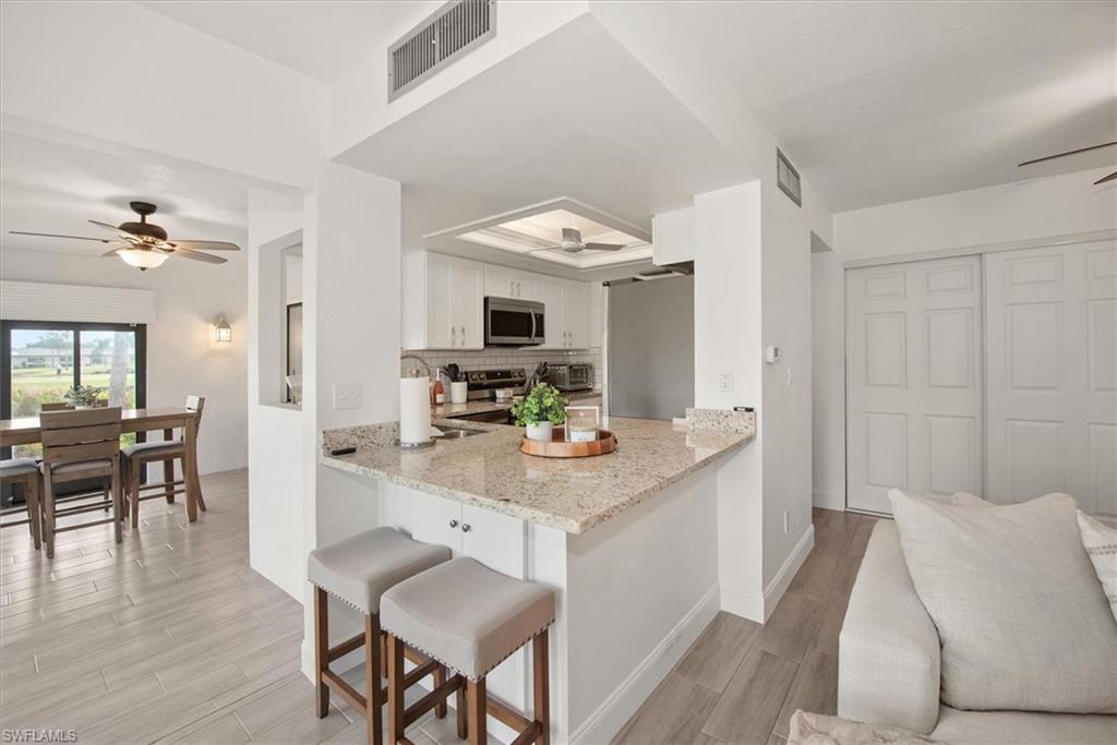 5665 Trailwinds Drive, Unit 616 Fort Myers, FL 33907 - Photo 9 of 29 a view of kitchen island table and chairs