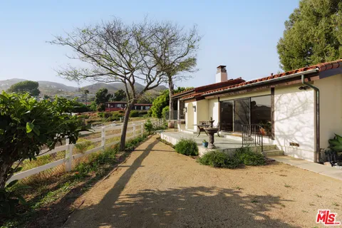 a view of a house with backyard and sitting area